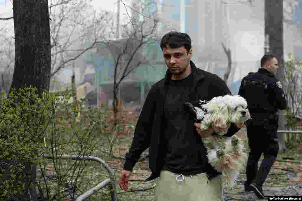 Місцевий житель зі своєю собакою на місці прильоту. Харків, 7 квітня 2024 року