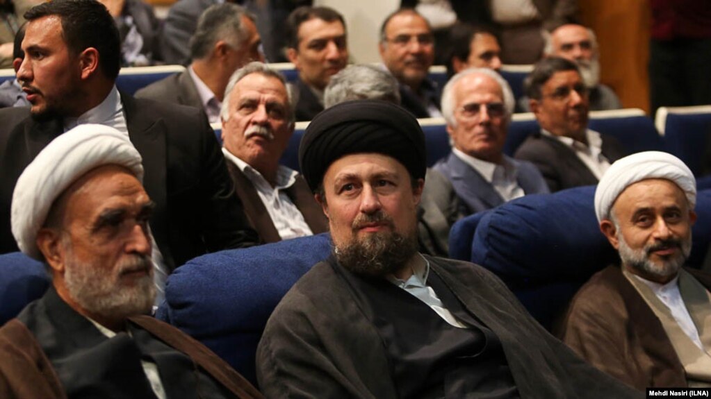حسن خمینی (با عمامه مشکی) در مراسم سالگرد مرگ محمود دعایی، مدیر سابق روزنامه اطلاعات