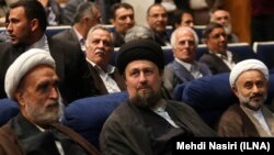 حسن خمینی (با عمامه مشکی) در مراسم سالگرد مرگ محمود دعایی، مدیر سابق روزنامه اطلاعات