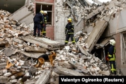 Salvatori ucraineni, la locul unei clădiri distruse în urma unui atac rusesc asupra orașului Cernihiv.