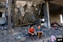 Djeca sjede među ruševinama zgrade nakon izraelskog napada u Rafi na jugu Pojasa Gaze, 10. novembra
