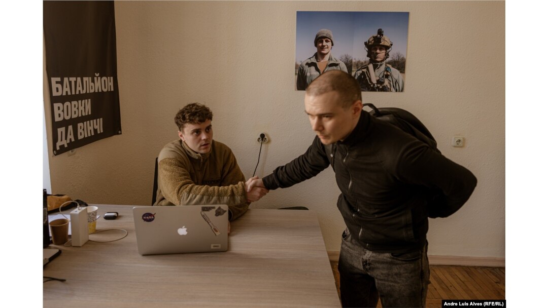 Dmytro Yasynok (right) meets with Maksym at the recruitment office of the Da Vinci Wolves Battalion in Kyiv.