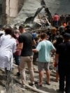 Люди, лікарі та рятувальники розбирають завали одного з корпусів лікарні після ракетного обстрілу дитячої лікарні «Охматдит» у Києві 8 липня 2024 р.
