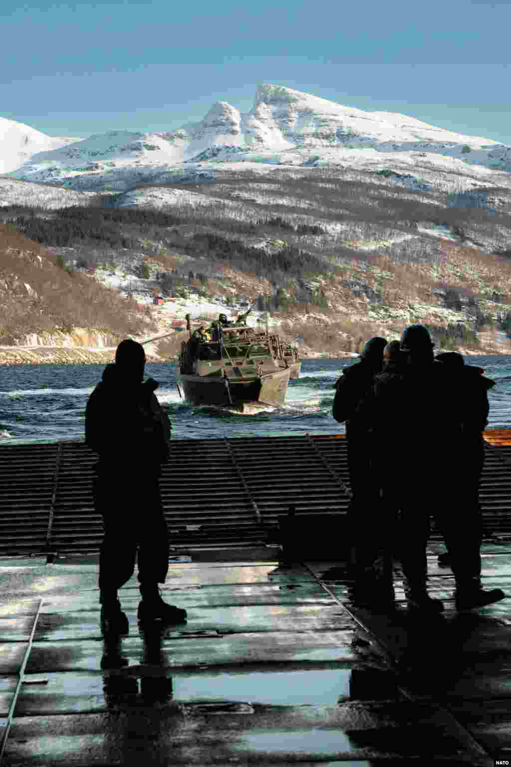 Шведский десантный катер приближается к военному кораблю США во время учений 29 февраля. В конце 2023 года Стокгольм и Вашингтон подписали соглашение, предоставляющее американским военным доступ к шведским базам и разрешающее хранение оружия и боеприпасов в этой скандинавской стране