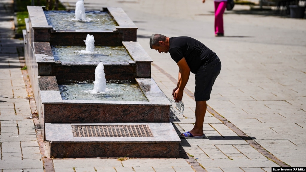 Një burrë freskon këmbë e duar me ujin e një shatërvani në Prishtinë ku të premten temperaturat shënuan 34 gradë.&nbsp;&nbsp;