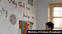 კულტურის მინისტრი ერთ-ერთ გამოფენაზე - კედელზე წერია ტექსტი თუფაქის ცნობილი სიმღერიდან "მხოლოდ ღმერთია ჩემი განმსჯელი" - 2022 წლის ივლისი 