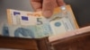 Kartëmonedha prej 100 dinarësh serb dhe kartëmonedha të valutës euro. Fotografi ilustruese. 