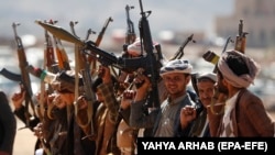 Newly recruited members of the Huthi army brandish weapons during a gathering at the end of a military training on the outskirts of Sanaa, Yemen, on January 22.