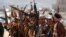 Newly recruited members of the Huthi army brandish weapons during a gathering at the end of a military training on the outskirts of Sanaa, Yemen, on January 22.