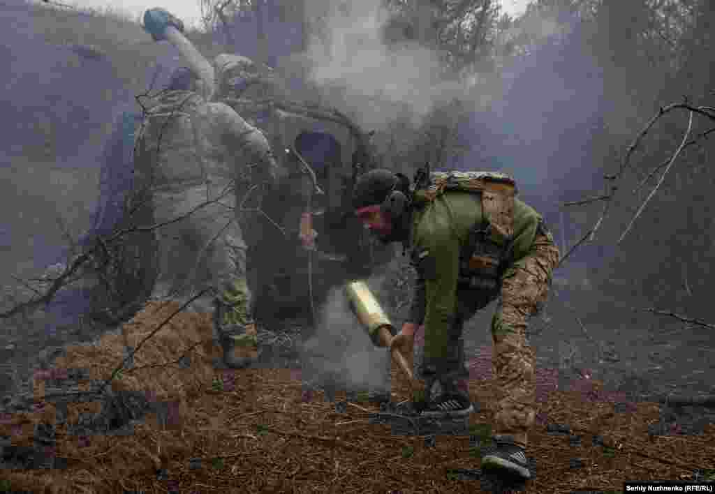 Soldiers work quickly to unload the base of a shell after a salvo is fired. RFE/RL photographer Serhiy Nuzhnenko is one of the few journalists granted access to the fighting along the front line.