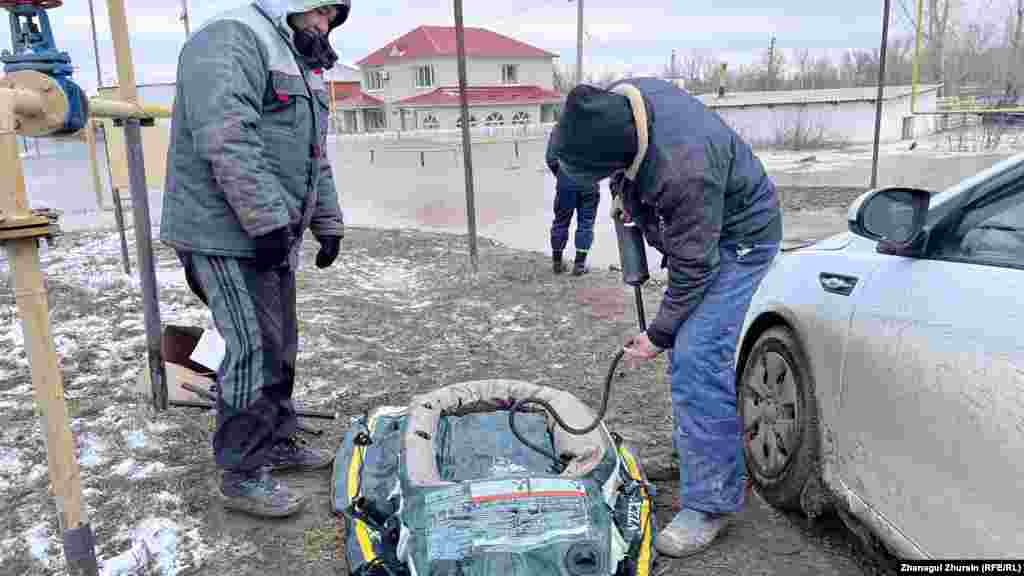 Further south of the nation&#39;s capital, a resident of Aqtobe prepares a rubber boat to reach his flooded house on the banks of the Elek River.