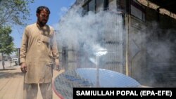 Local blacksmith Ghulam Abbas tests a solar stove that he built at his workshop in Kabul on May 8. The parabola-shaped solar heaters have grown in popularity in Afghanistan as the country is in the grip of a chronic energy crisis.