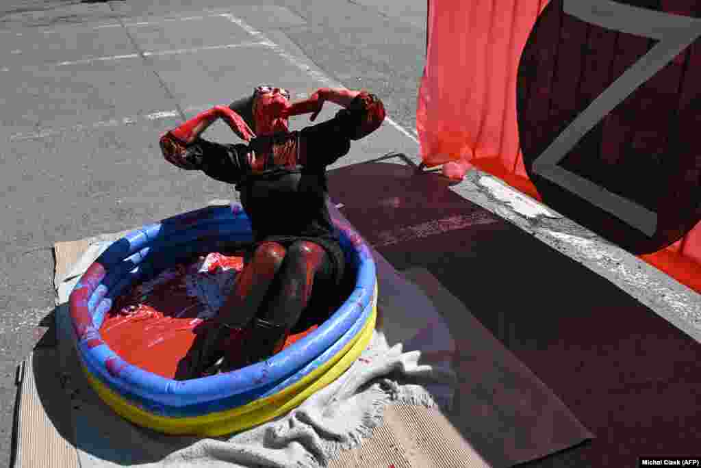 Anti-Russia and anti-war activist Julie Levkova protests with red paint in front of the Russian Embassy in Prague.