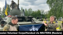 Члены военного подразделения "Русского добровольческого корпуса" (РДК) возле бронированной машины, Белгородская область России. Это фото РДК обнародовал 23 мая 2023 года