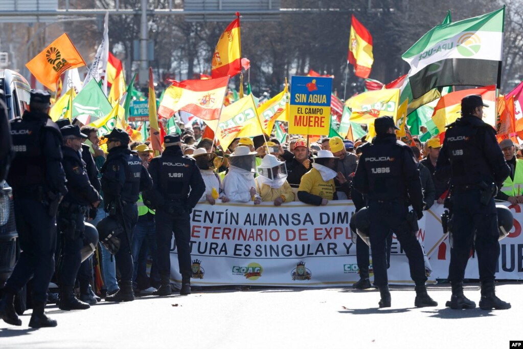 Fermerët mbajnë flamuj spanjollë dhe një pankartë me mbishkrimin &quot;Pa ujë, fushat vdesin&quot; gjatë një proteste kundër kushteve të këqija të punës për fermerët dhe politikat evropiane për bujqësinë, Madrid, më 26 shkurt 2024.