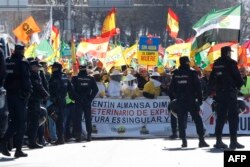 Poljoprivrednici drže zastave Španije i natpis "Bez vode, polja umiru" tokom protesta zbog loših uslova za rad farmera i evropske poljoprivredne politike, u Madridu, 26. februara 2024.