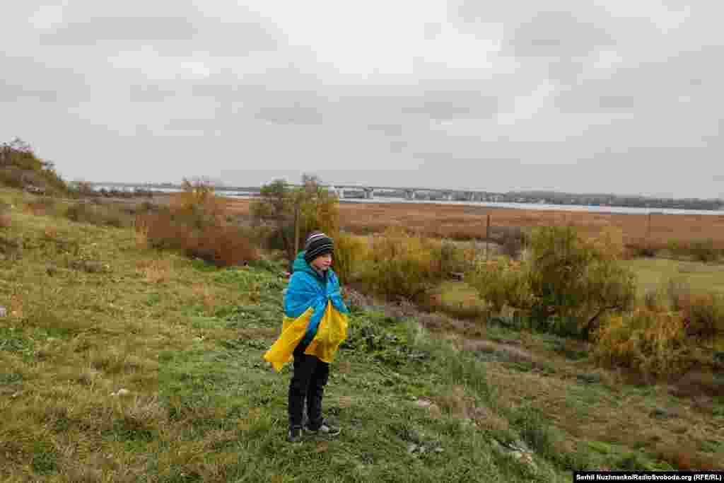 Хлопчик на березі Дніпра, неподалік Антонівського мосту. Листопад 2022 року