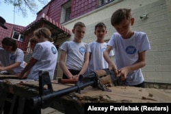 Дети учатся сборке-разборке автомата в оздоровительном лагере. Севастополь, 19 мая 2023 года