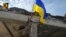 Український військовий встановлює прапор на укріпленні в Курській області