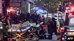Bolničari guraju nosila u tržni centar Westfield Bondi Junction kako bi izvukli povrijeđene nakon napada nožem u Sidneju 13. aprila 2024. 