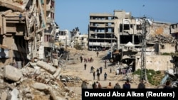Палестинците се движат меѓу урнатините во градот Газа, 20 март 2024 г.