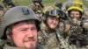 RUSSIA – Members of Russian Volunteer Corps pose for a picture atop an armoured vehicle at Graivoron border crossing in Kozinka, Belgorod region, Russia, in this handout picture released on May 23, 2023