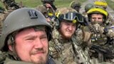 RUSSIA – Members of Russian Volunteer Corps pose for a picture atop an armoured vehicle at Graivoron border crossing in Kozinka, Belgorod region, Russia, in this handout picture released on May 23, 2023