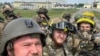 RUSSIA – Members of Russian Volunteer Corps pose for a picture atop an armoured vehicle at Graivoron border crossing in Kozinka, Belgorod region, Russia, in this handout picture released on May 23, 2023