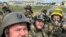 RUSSIA – Members of Russian Volunteer Corps pose for a picture atop an armoured vehicle at Graivoron border crossing in Kozinka, Belgorod region, Russia, in this handout picture released on May 23, 2023