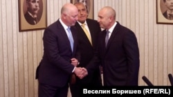 Президентът Румен Радев и предложеният за премиер от ГЕРБ Росен Желязков се ръкуват на фона на Бойко Борисов.