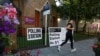 Žena trči pored glasačkog mesta u Londonu ubrzo pošto su otvorena birališta na izborima u Velikoj Britaniji, 4. jul 2024.