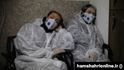 Two young doctors sleep between shifts at an Iranian hospital.