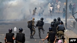 Police use tear gas to disperse Pakistan Tehreek-e-Insaf party activists and supporters of former Pakistani Prime Minister Imran Khan during a protest against his arrest in Lahore on May 10.