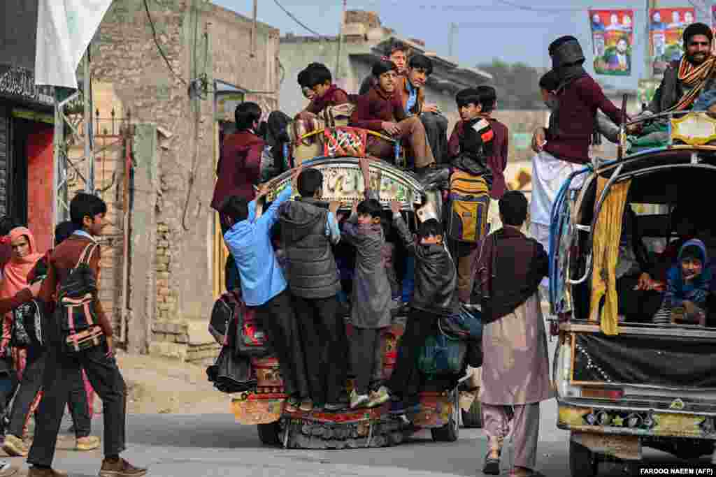 Children travel on a van as they return from school on the outskirts of Talagang, Pakistan.
