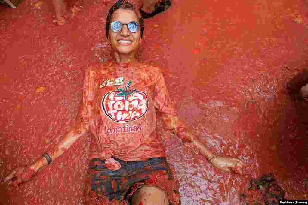 Žena leži na zgnječenom paradajzu tokom godišnjeg festivala La Tomatina u Bunolu, blizu Valensije, Španija, 28. avgusta 2024.