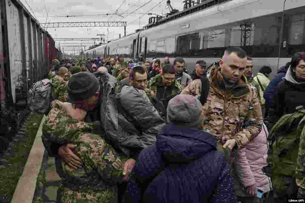 A female Ukrainian soldier (left) kisses her husband as they meet at a railway station close to the front line in Kramatorsk.