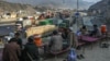 Drivers rest as stranded trucks are pictured near the Pakistan-Afghanistan border at Torkham on January 16. 