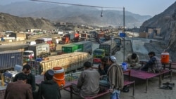 Drivers rest on the roadside as stranded trucks are pictured near the Pakistan-Afghanistan border in Torkham during a previous closure in 2024. 
