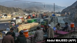 Drivers rest on the roadside as stranded trucks are pictured near the Pakistan-Afghanistan border in Torkham during a previous closure in 2024. 