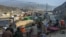 Drivers rest on the roadside as stranded trucks are pictured near the Pakistan-Afghanistan border in Torkham during a previous closure in 2024. 