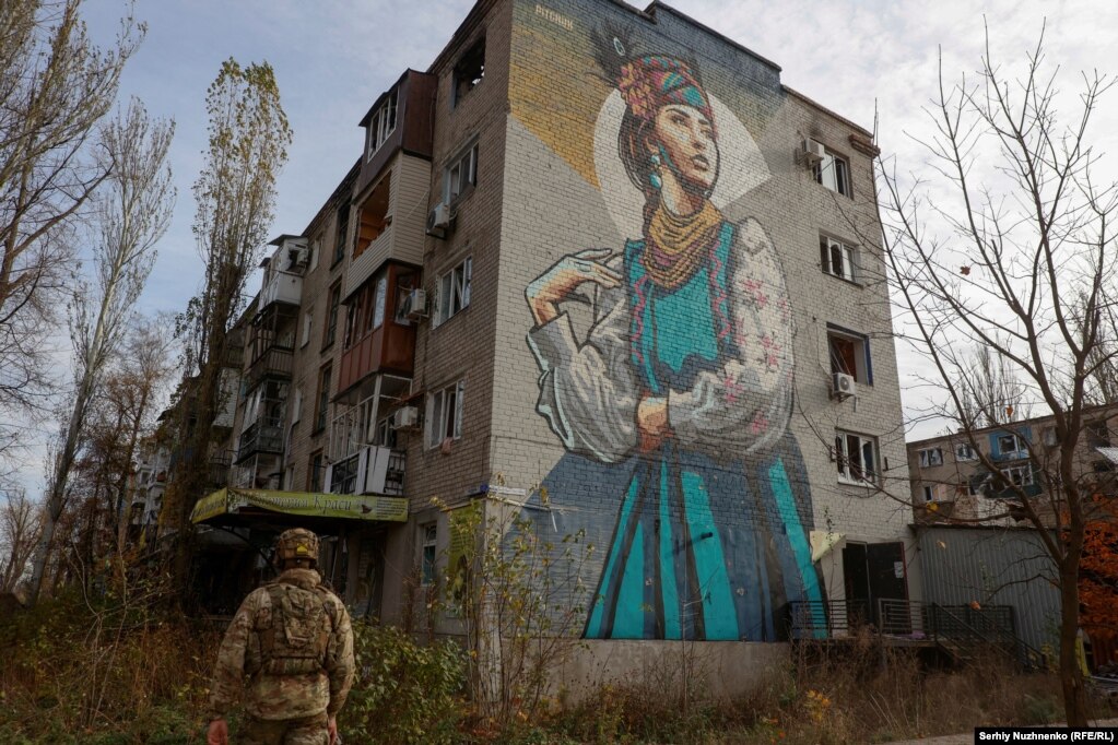  Un soldato ucraino cammina accanto a un condominio danneggiato.   Un importante snodo dei trasporti, Avdiyivka, si trova a soli 15 chilometri a nord della città di Donetsk occupata dai russi.  È sotto assedio da quando Mosca ha lanciato un’importante offensiva all’inizio di ottobre.