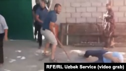 Umid Miraliev (on the ground) is beaten by a group of unknown men in a video taken by his friend.