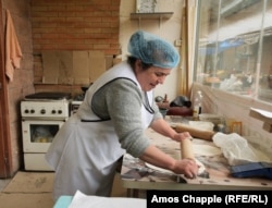 A woman in Abovyan, who fled her home in Stepanakert in September 2023, rolls dough for jingalov hats. In and around the central market of Abovyan, at least three separate businesses run by Karabakh Armenian refugees sell the traditional dish.