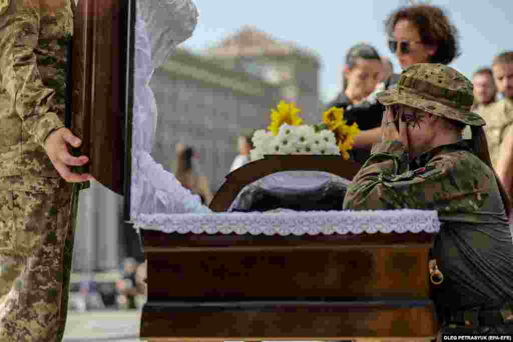 Comrades of late Ukrainian commander Serhiy Ilnitkiy pay their respects during a memorial service on Independence Square in Kyiv on August 28, after he was killed fighting in the Donetsk region on August 23.