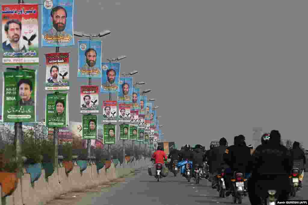 Commuters pass election campaign posters ahead of general elections in Rawalpindi on January 9. Pakistan will be having new elections on February 8. To ensure that each eligible voter has a say in the political process, each political party is assigned a unique symbol that is displayed next to the party&#39;s name. &nbsp;