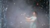 ROMANIA -- Girls take pictures as she is engulfed by mist from a public fountain in Bucharest, July 17, 2023. 