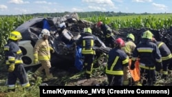 Emergency crews work at the site of a minibus crash that killed 14 people in Ukraine on July 6.