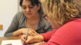 Rozina, a Rom from Ukraine's Transcarpathia region, practices her writing with Agnes Pletser from the Taleta NGO.