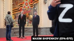 Вырезанные из картона изображения руководителя России Владимира Путина (слева) и президента Китая Си Цзиньпина возле сувенирного магазина в центре Москвы во время визита Путина в Пекин, 16 мая 2024 года