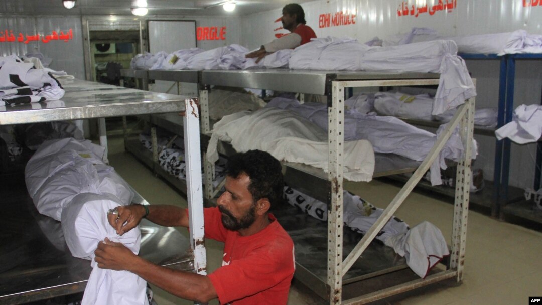 Pakistani volunteers adjust the dead bodies of heatwave victims at a morgue in Karachi late last month.